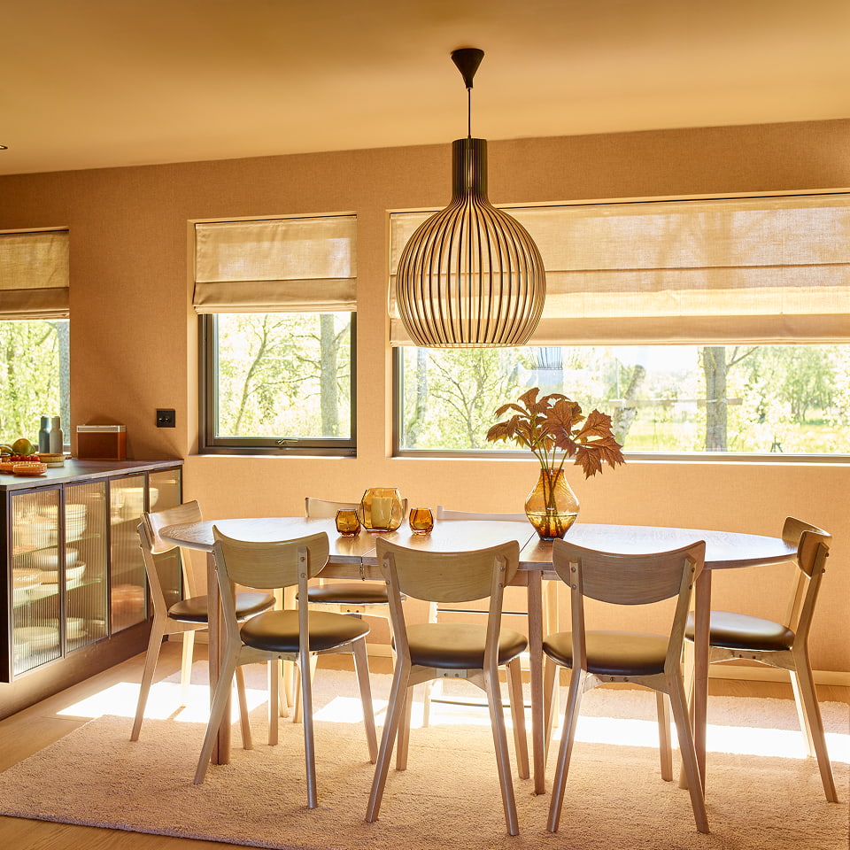 Spisebord med stoler rundt og en lampe som henger over. 