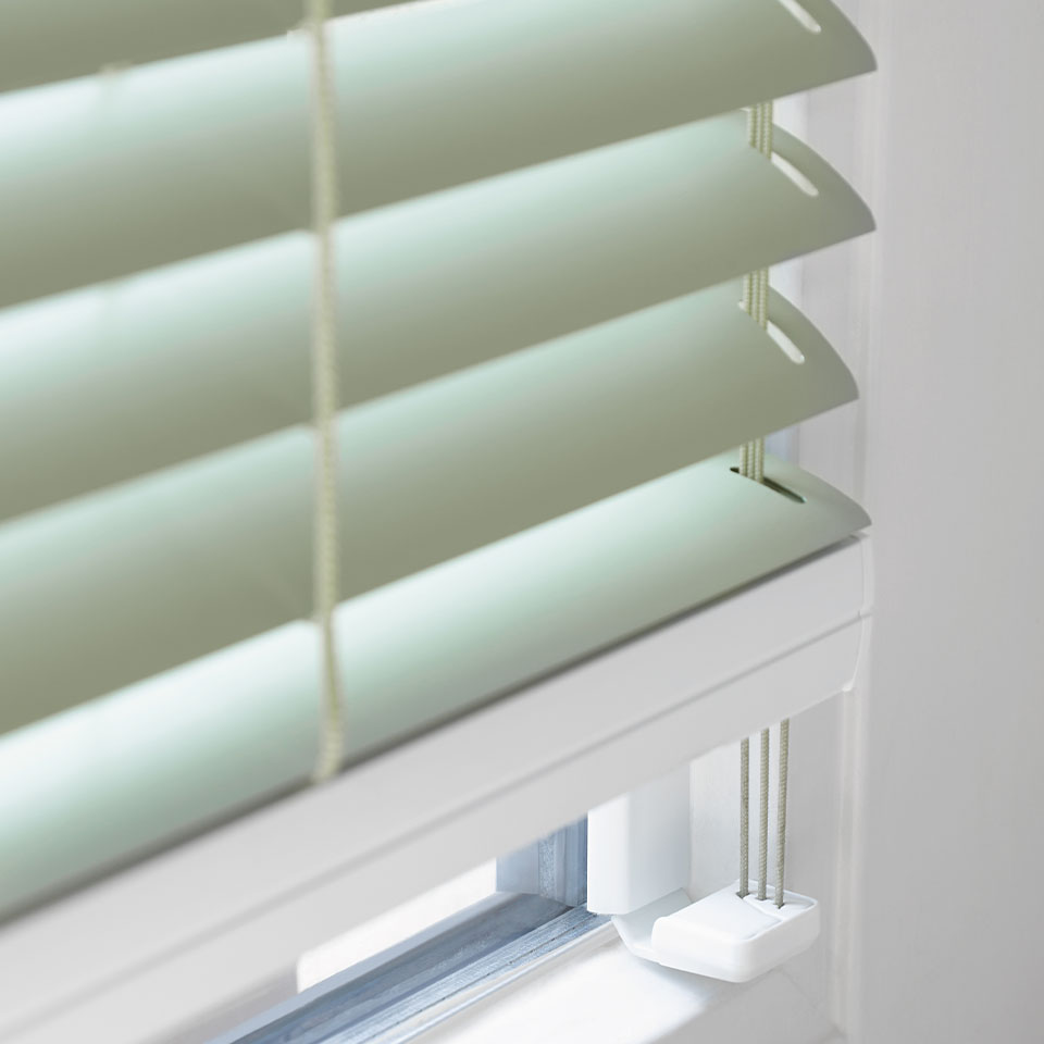 Hvitt rom og hvit vinduskarm med dus-grønn persienne