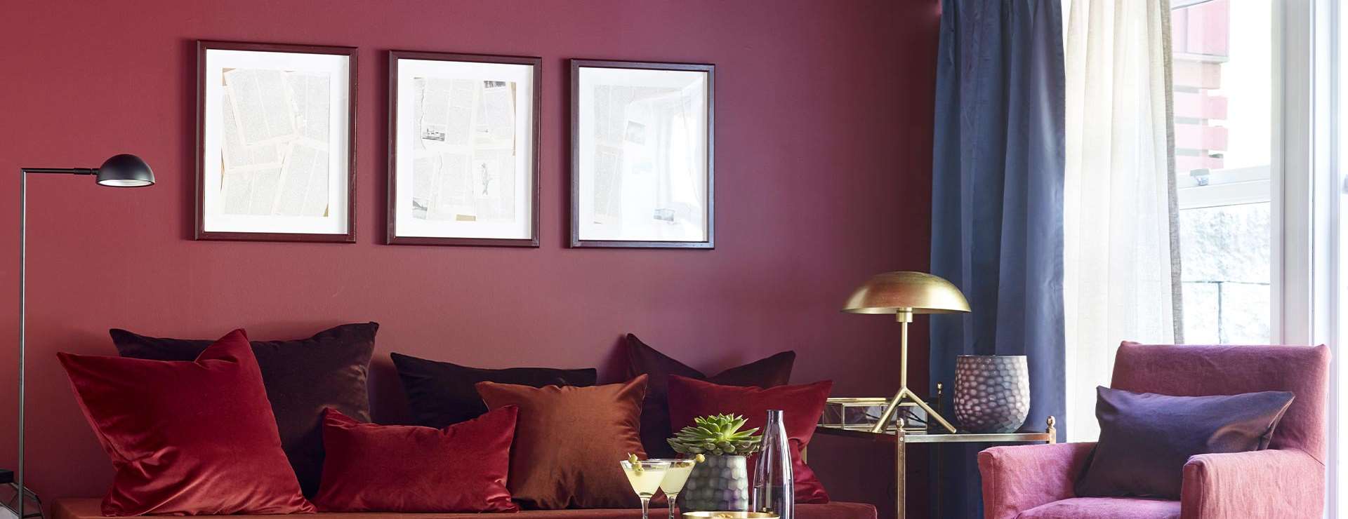 Stue med vegg, sofa, puter og stol i årets farge 2017 - rød