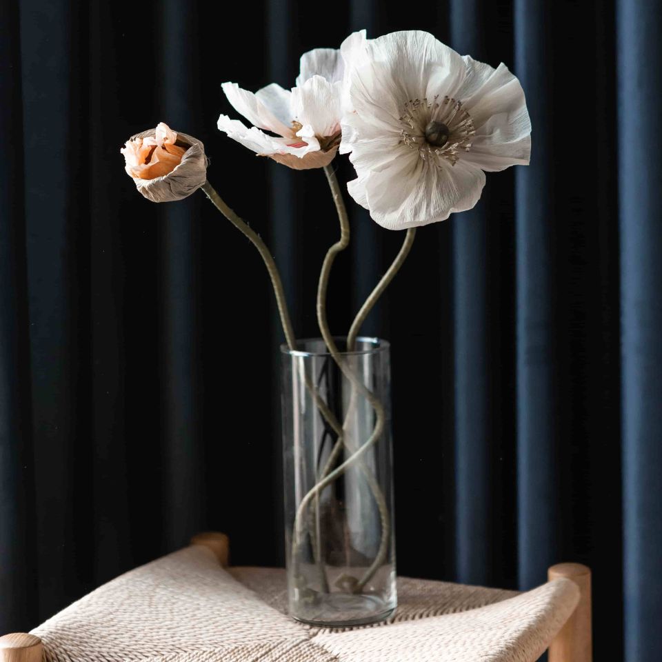 Miljøbilde av gardin med blomstervase foran