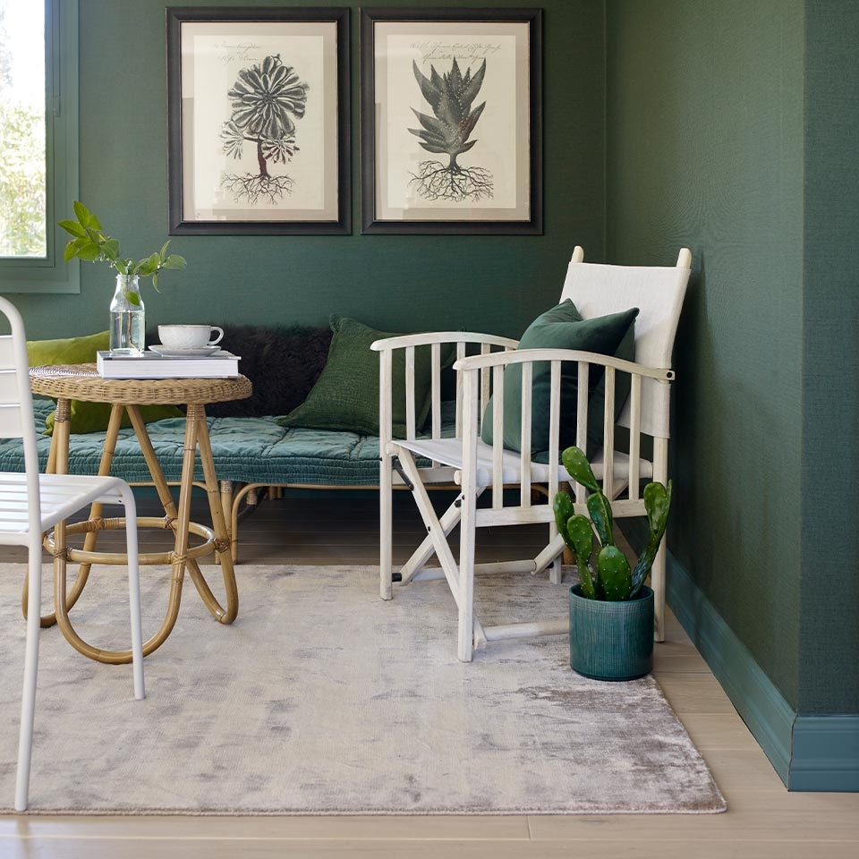 Grønn stue med lyst teppe.