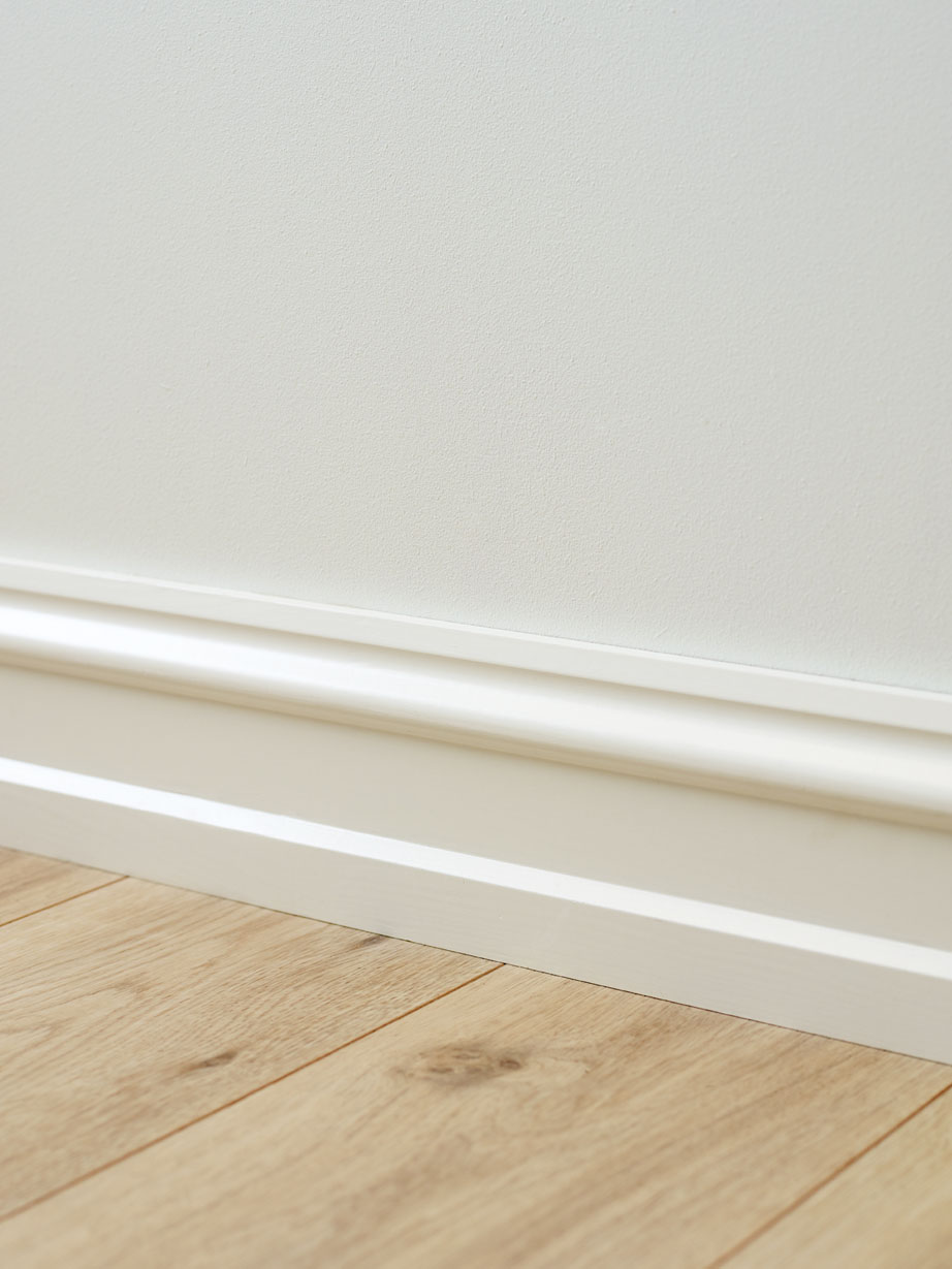 Lyst gulv med perfekt hvit malt på listene