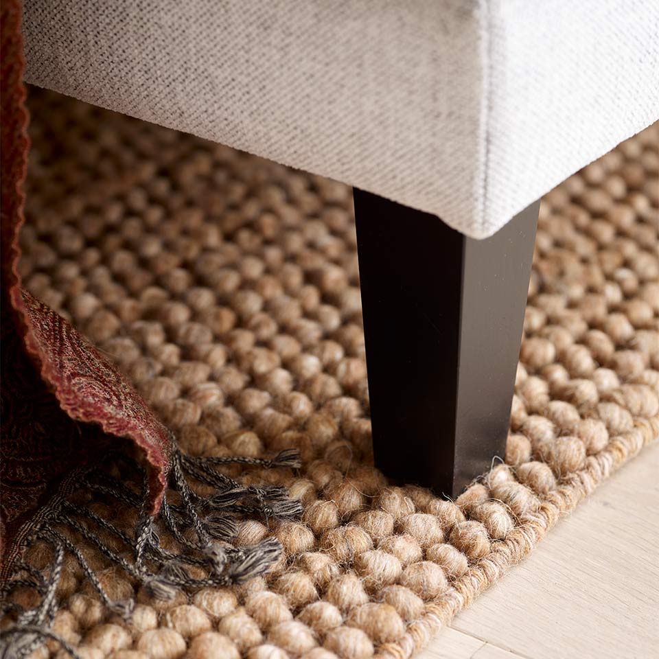 Lunt beige teppe under sofaben