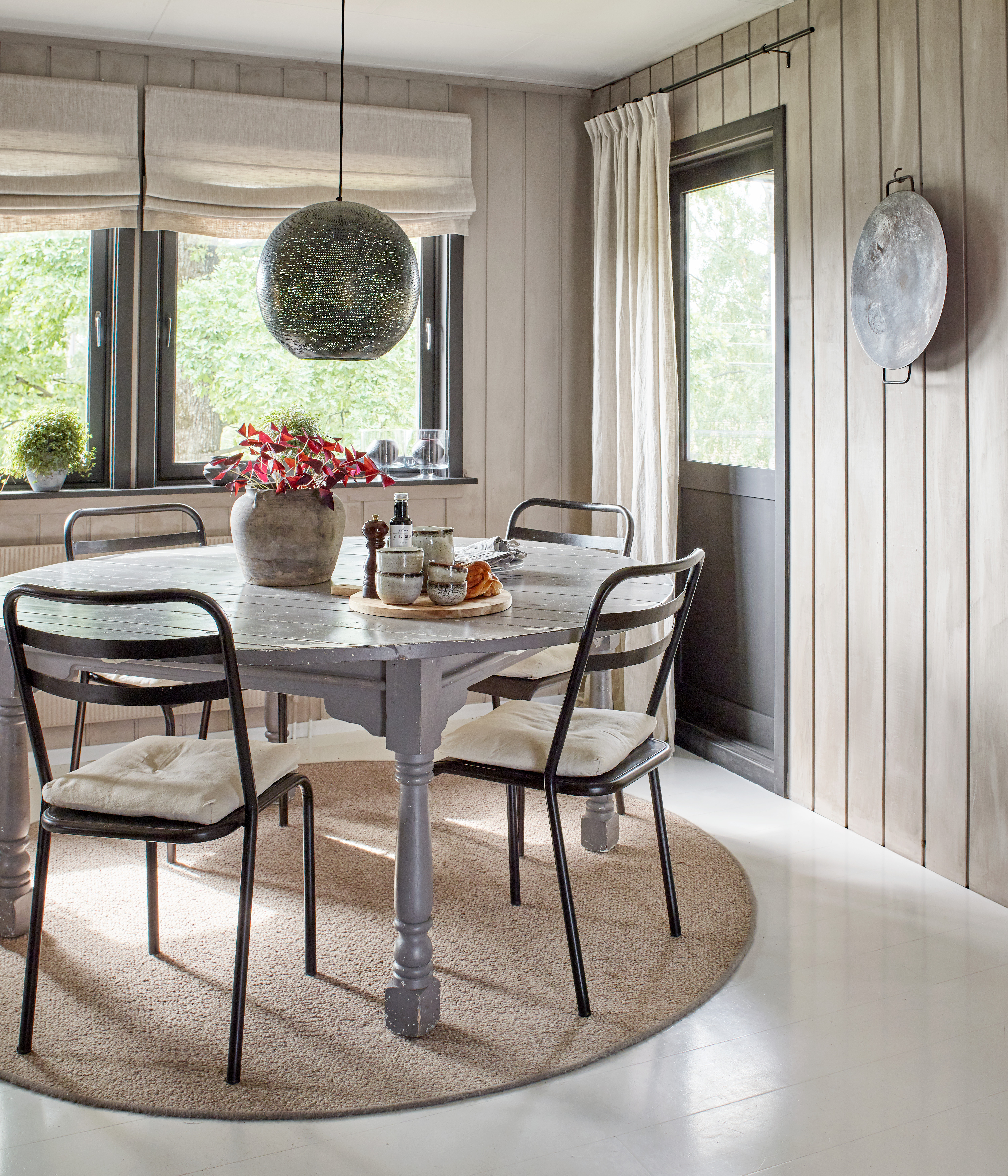 Grått bord med fire stoler på kjøkken.