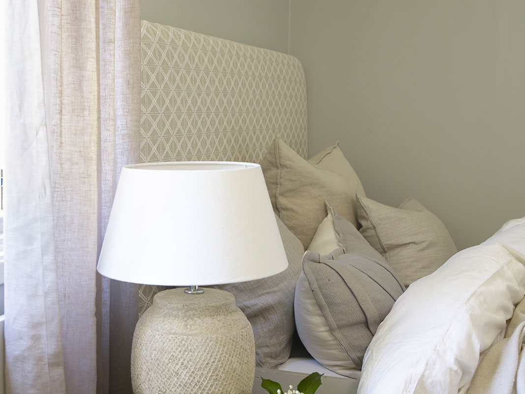 Sengegavl i beige stoff.