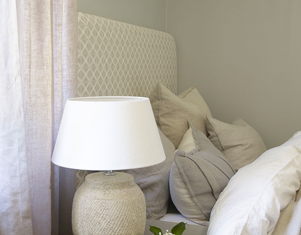 Sengegavl i beige stoff.