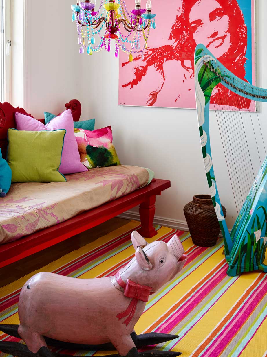 Rosa gyngegris og rød sofa