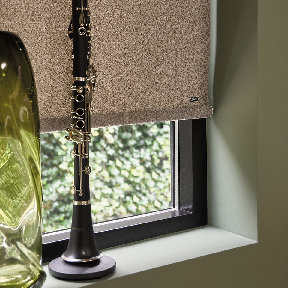 Mørkleggende og tett rullegardin i jordfarge foran vindu