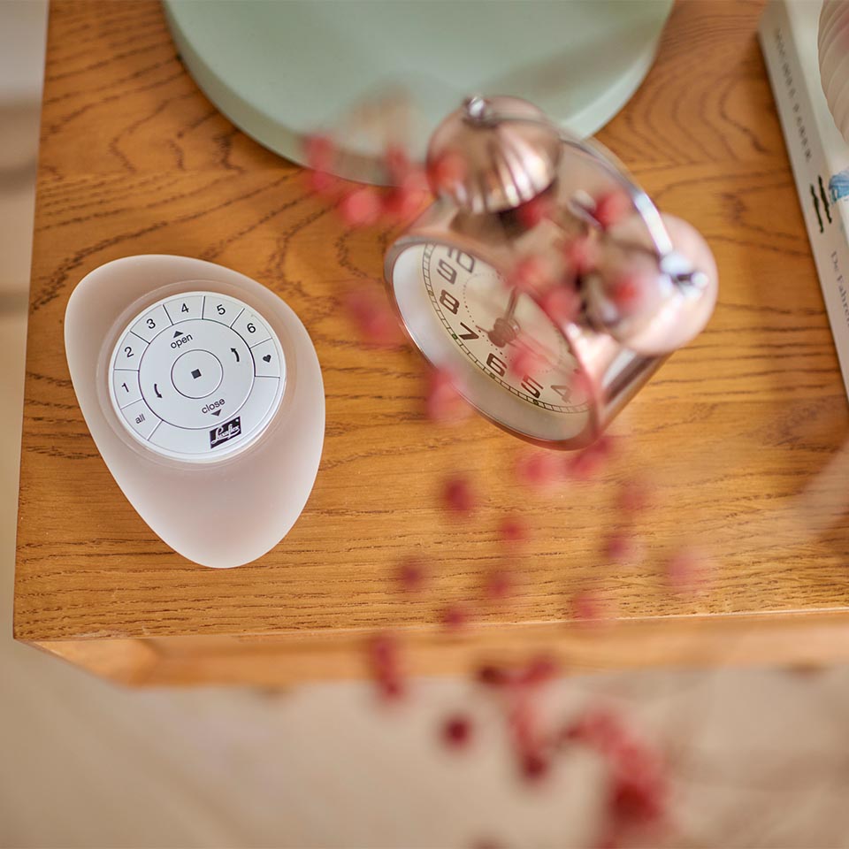 Fjernkontroll til motorisert solskjerming ligger diskret på et bord