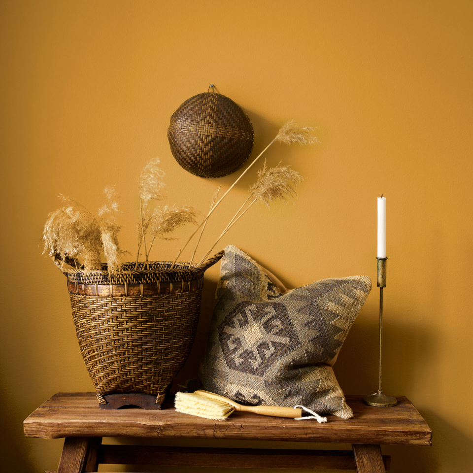 To puter foran sennepsgul vegg