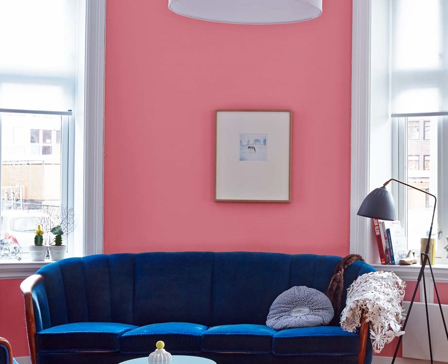 Stue med rosa vegger og blå sofa
