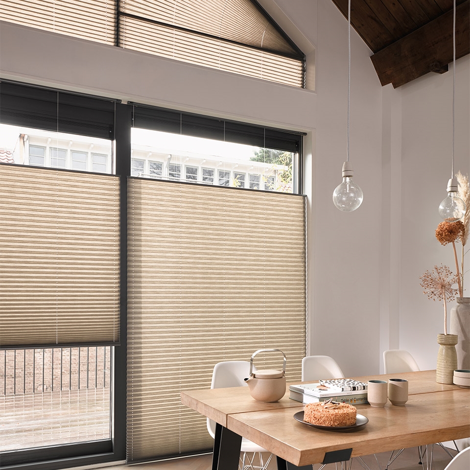 Stort vindu og terrassedør med justerbar plisségardin ved spisebord