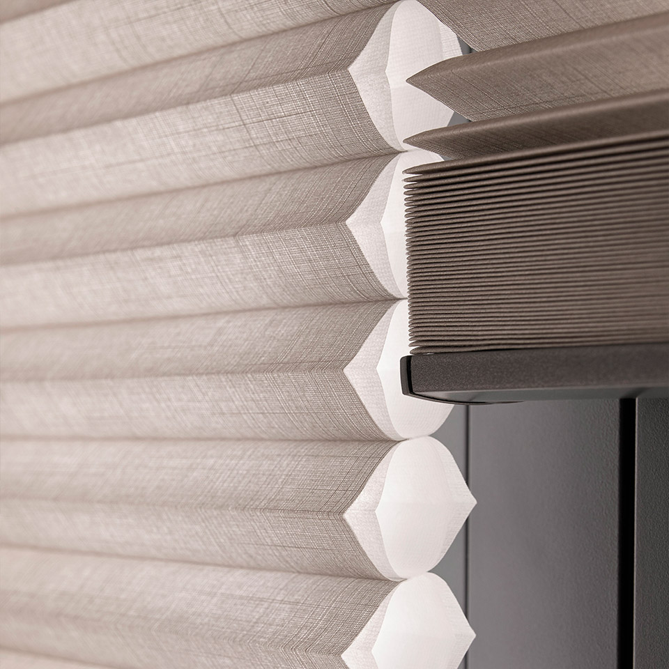 Nærbilde av Duette plisségardin for illustrasjon av lagenes funksjon med vev som skaper celler med luft.