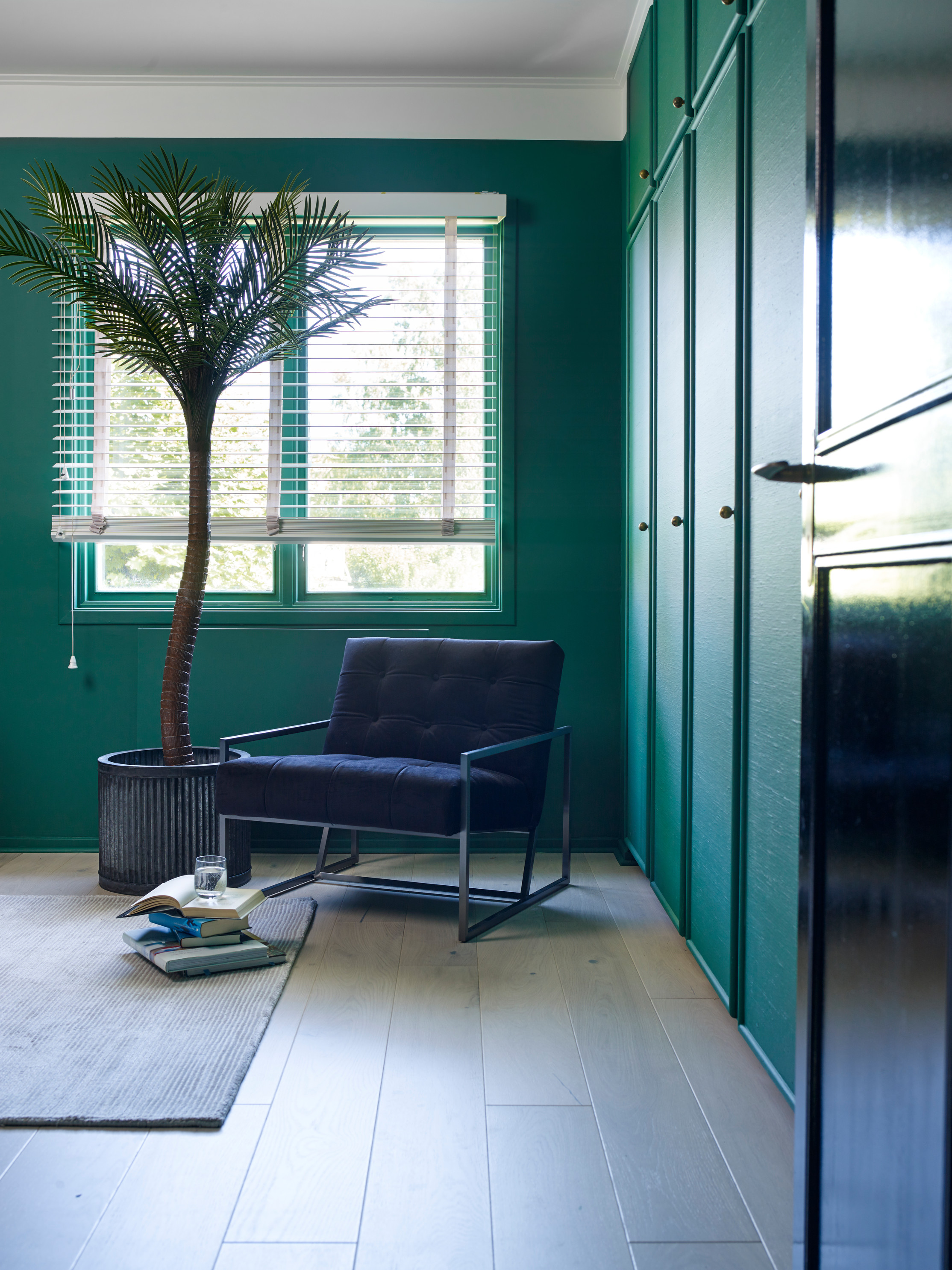 Lenestol i mørkt skinn mot en frisk grønn vegg malt i Beatle-grønn