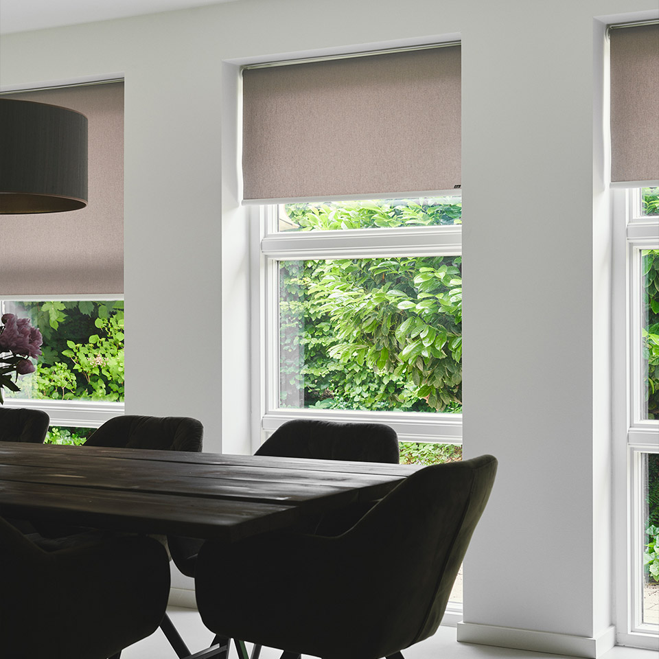 Spisestue med store vindusflater, solskjermet med rullegardiner i lys  farge