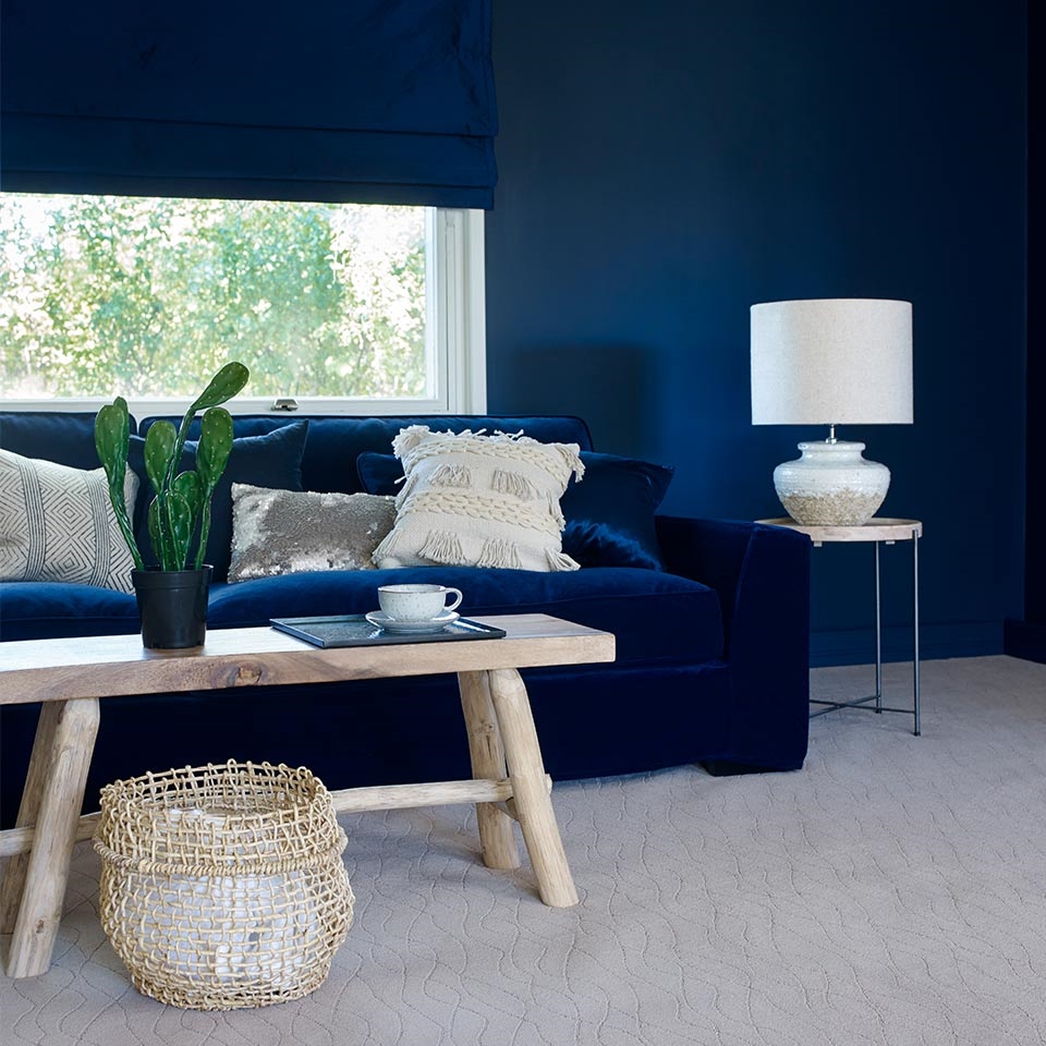 Blå stue med blå sofa og vegg-til-veggteppe