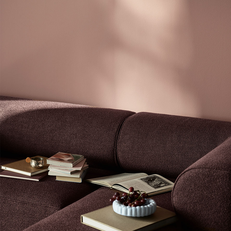 Rosa vegg og burgunder sofa